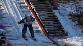 A young girl smiles as she skis down the 8-meter Red Wing Hill at Mount Itasca on Feb. 17, 2024.