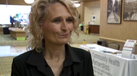 A woman with blonde curly hair looks off camera.