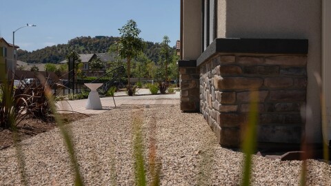 Gravel covers a five-foot non-combustible buffer in front of a model home in the Dixon Trail neighborhood of Escondido on April 24, 2025. The buffer zone helps reduce the chances of a home being ignited by the embers from a wildfire. Developer KB Home is marketing Dixon Trail as the first “wildfire resilient neighborhood” in the U.S., constructed using fire-resistant materials and methods.