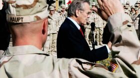 SPC Steven Haupt of the 173rd Airborne (L) raises his hand to take his re-enlistment oath from US Secretary of Defense Donald Rumsfeld during a ceremony 22 December 2005 in Khandahar, Afghanistan before Rumsfeld left for Baghdad. (Jim Young/AFP via Getty Images)
