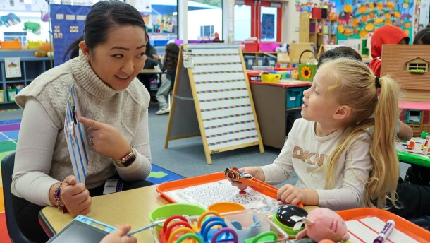 Student-teacher Yer Yang points to a picture of a horse as she asks one student to sound out the word.