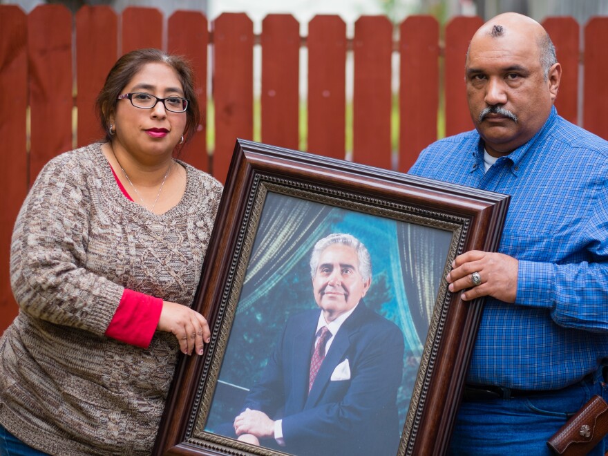 Patty Rodriguez and her brother Alex hold a photo of their father, Demetrio Rodriguez, who died in 2013.