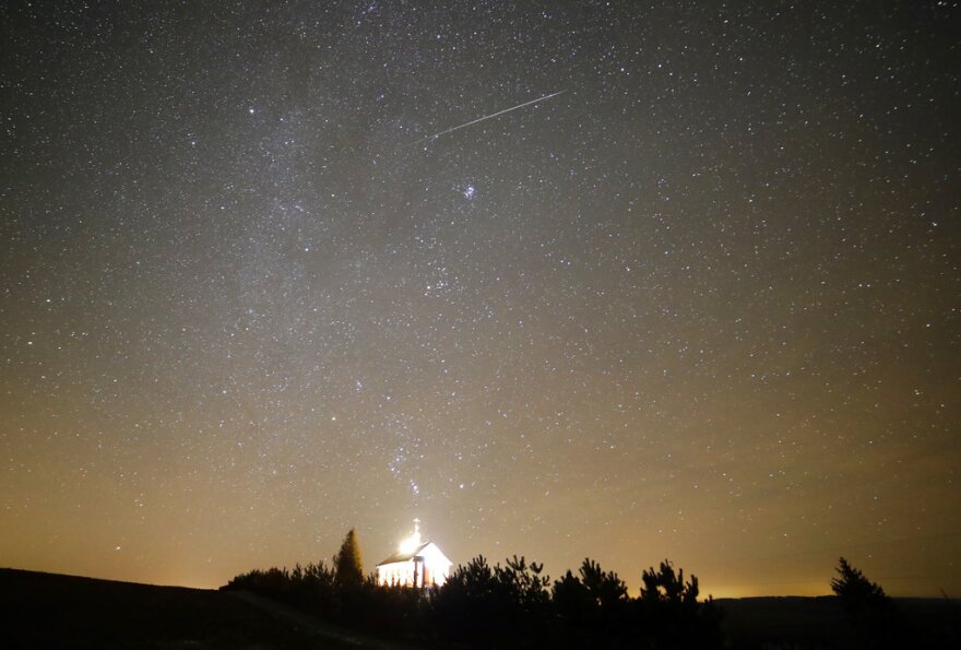 A meteor streaks across the sky during the annual Geminids meteor shower over an Orthodox church on the local cemetery near the village of Zagorie, some 110 km ( 69 miles) west of capital Minsk, Belarus, late Wednesday, Dec. 13, 2017.