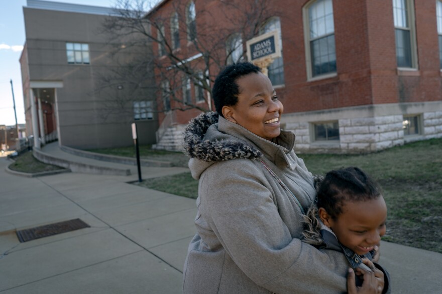 Menishia hugs her 8-year-old daughter, Angelina, after picking her up from Adams Elementary School. The family has been homeless for nearly two years and getting to school on time is a constant struggle.