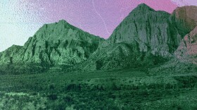 Desert mountains tinted green against a purple sky