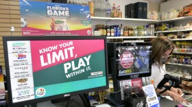 A clerk takes an order for lottery tickets on Jan. 13, 2021, in Orlando.