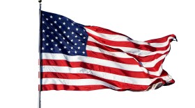 Large U.S. Flag "Old Glory" blowing in a strong wind on a cloudless day - isolated on white background