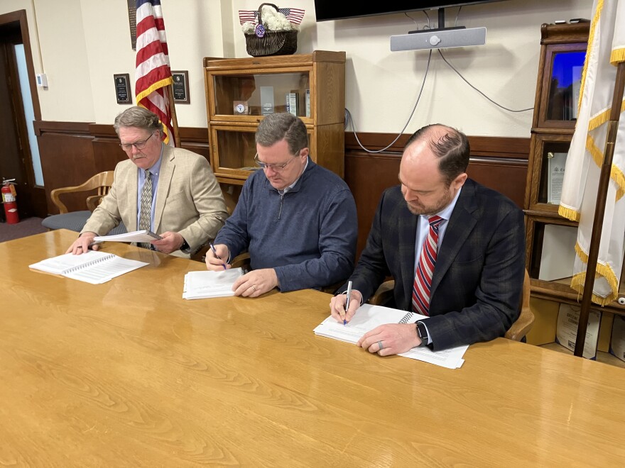 Flanked by the flags of the United States and Greene County, county commissioners Rusty MacLachlan, Bob Dixon and John Russell signed the 2025 budget into law on January 10, 2025.