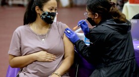 Nicole Fahey, six months pregnant, receives a Pfizer vaccination from a nurse on Nov. 3, 2021 in Los Angeles, CA.