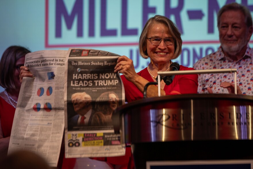 Mariannette Miller-Meeks holds up a copy of the Des Moines Register
