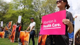  A woman holds a sign in support of abortion rights in front of those holding signs against it at a "Bans Off Our Bodies" protest on May 14, 2022, in Ann Arbor, Michigan. 