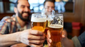 people, men, leisure, friendship and celebration concept - happy male friends drinking beer and clinking glasses at bar or pub