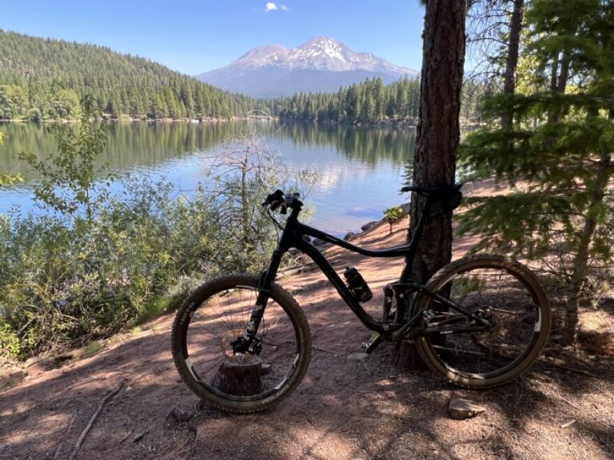 Lake Siskiyou Trail along the shoreline near Mount Shasta, with a wide path, trees and views of the lake and surrounding mountains.