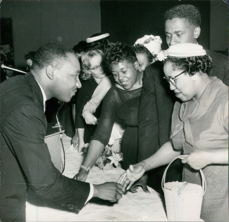 A digitized photograph of Martin Luther King Jr. speaking interacting with a crowd at Illinois Wesleyan University in 1961.