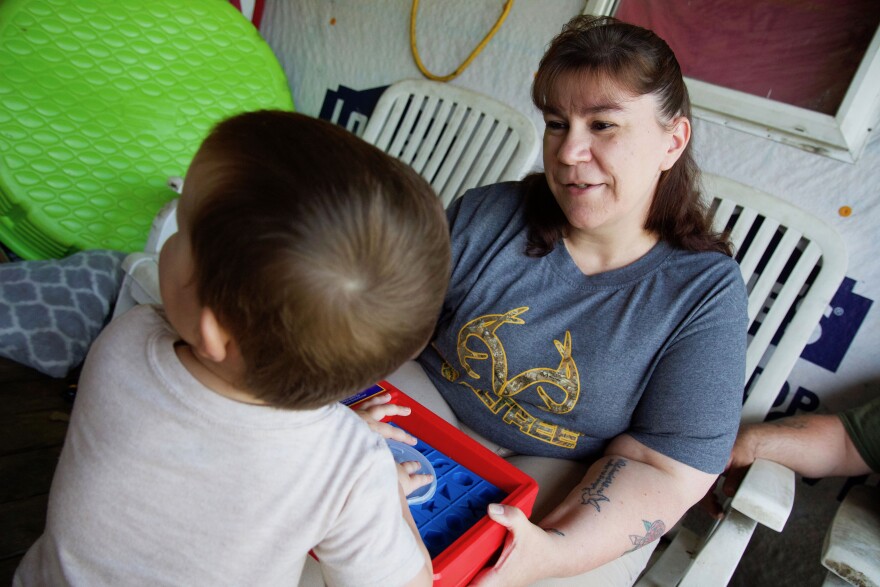 A woman plays with a young boy.