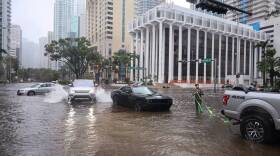 Late model luxury Land Rover speeds through as a stranded driver tries to tow his car out of the flooded intersection. Tropical Storm Eta slammed into Miami leaving motorists crossing the intersection of SW 13th Street and Brickell Avenue stuck in flood water in heavy rains due to the storms weather bands on Monday, November 9, 2020.