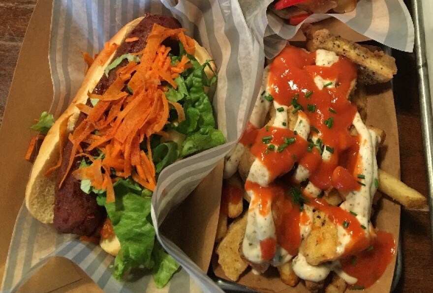 A photo of a vegetarian bratwurst and cheese curd fries