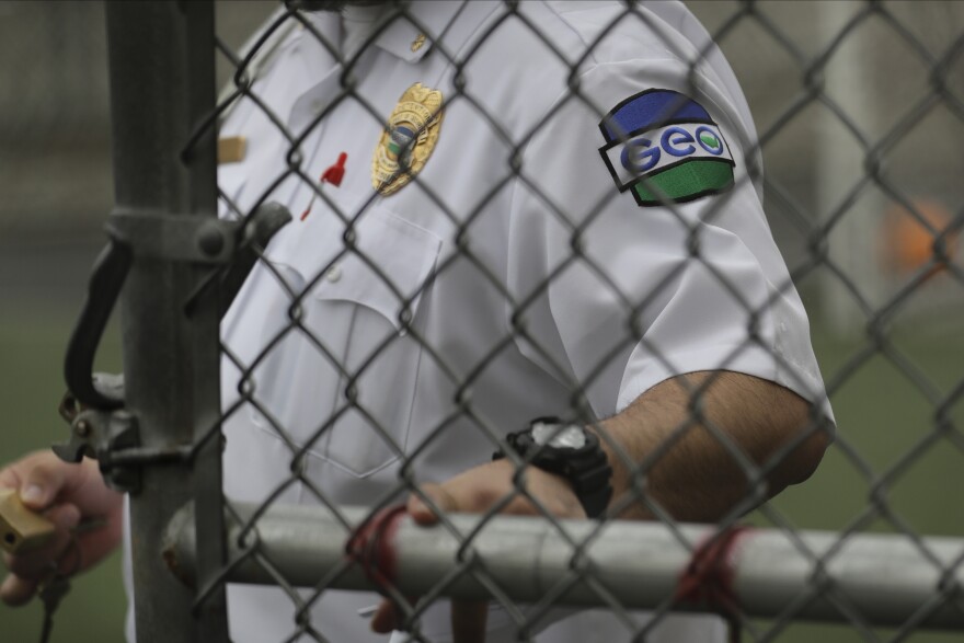 A patch is shown on the uniform of a guard with the GEO Group, Inc., during a media tour of the U.S. Immigration and Customs Enforcement detention center, Monday, Dec. 16, 2019, in Tacoma, Wash. The GEO Group is the private company that operates the center for the U.S. Government.