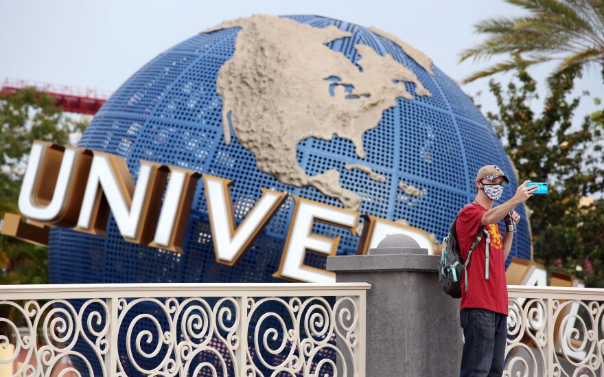 A visitor takes a selfie at Universal Studios theme park on June 5, the first day of the park's reopening during the coronavirus pandemic in Orlando, Fla.
