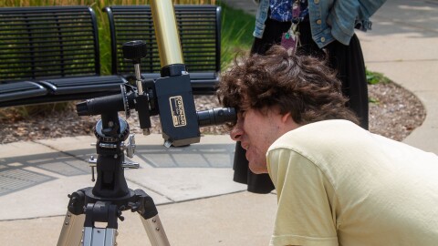 A person looking through a telescope.