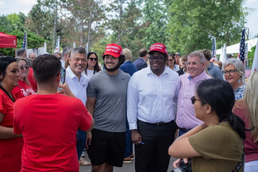 Darren Bailey and Aaron Del Mar, the Republican ticket for governor in 2026, pose for a photo with two fairgoers in “Make America Great Again” hats on Aug. 20, 2026.
