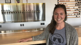 Carolyn Stiles, of Rochester Beer Gals, poses in front of taps at Fifth Frame Brewing
