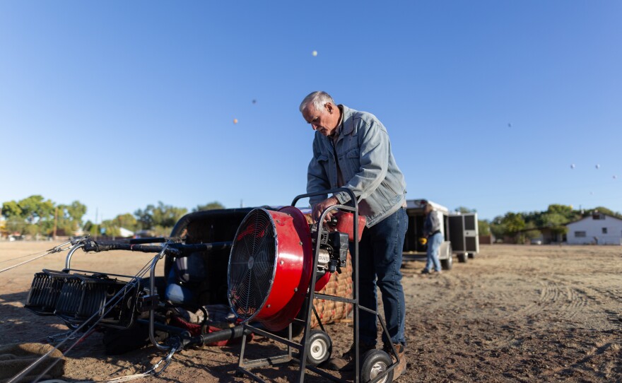 Pilot Gary Michalek pours gasoline into a fan, which is used, alongside a propane burner, to inflate the balloon’s envelope.