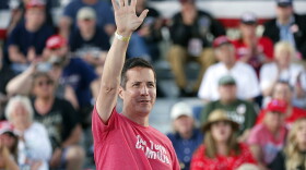 Bernie Moreno, in a red shirt, waves to a crowd