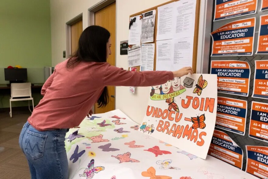 Dream Resource Center Lead D’arcy Corwin hangs up art created by students.