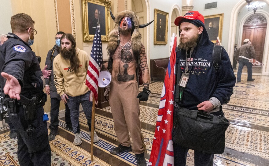 Rioters are confronted by Capitol Police officers outside the Senate Chamber.