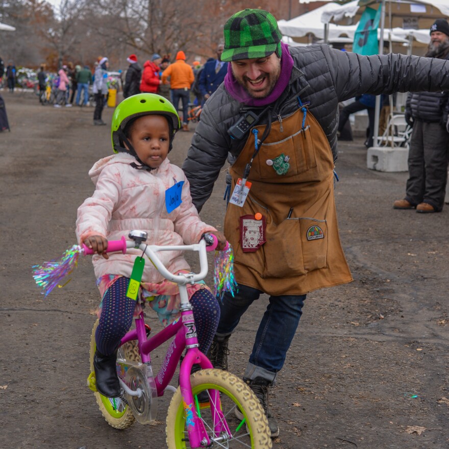 Devin McComas, the Executive Director of the Boise Bicycle Project, with a child on their new bike.