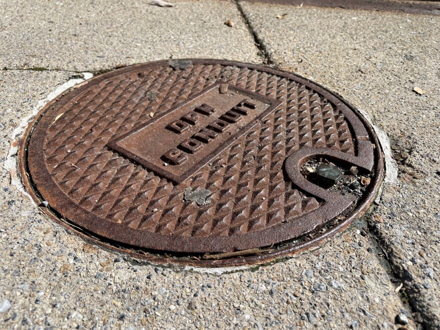 The portal that leads into Baltimore City's sprawling conduit system is visible on the average city sidewalk.