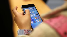 In this Sept. 25, 2015, file photo, a child holds an Apple iPhone 6S at an Apple store on Chicago's Magnificent Mile in Chicago.