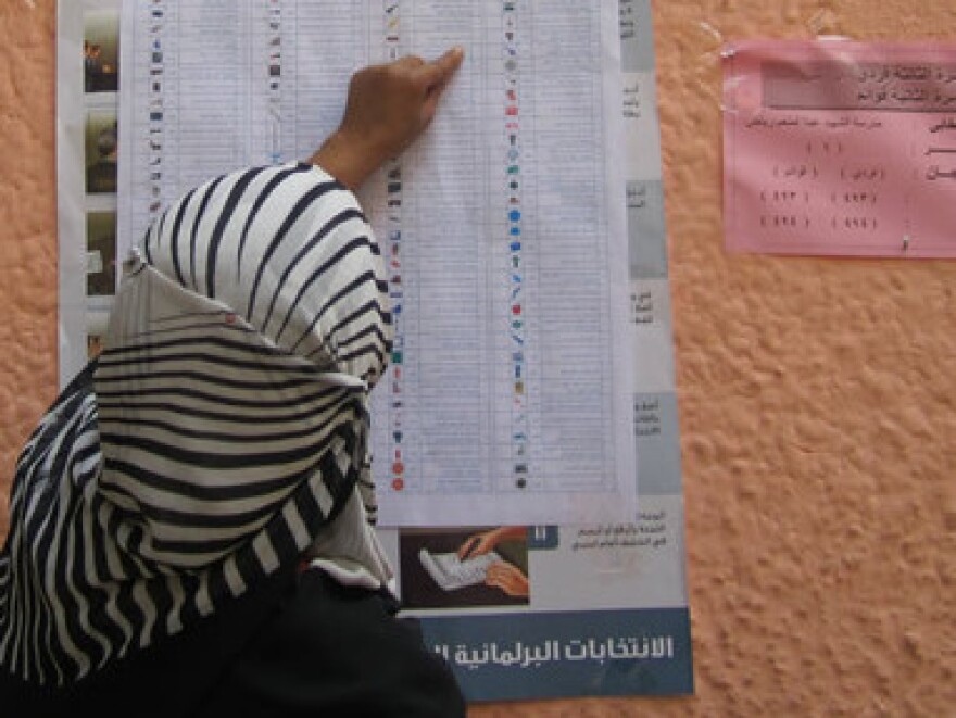 A voter checks a sample ballot outside a polling station during the second round of municipal elections in Egypt. The National Democratic Institute says it has helped mobilize volunteers and make parties aware of citizens' needs in Egypt without promoting a particular ideology.