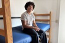 College student on his bed in his dorm room