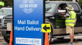 A voter pulls up to the drive-thru ballot drop-off location on Airport Boulevard.