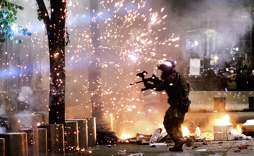 A federal officer fires crowd control munitions at protesters on July 24, 2020, in Portland, Ore. Some critics say media coverage of the protests in Portland and elsewhere last summer helped conflate Black Lives Matter protesters with individuals who associate with antifa.