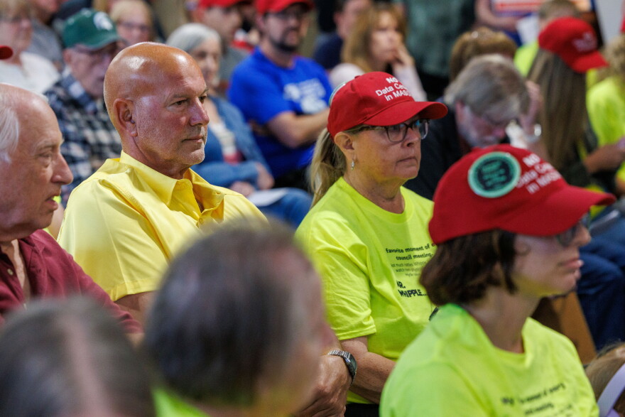 Community members opposing potential data center developments in Mason, Mich., wear custom red hats while attending a Mason City Council meeting and town hall on Sept. 14, 2026.