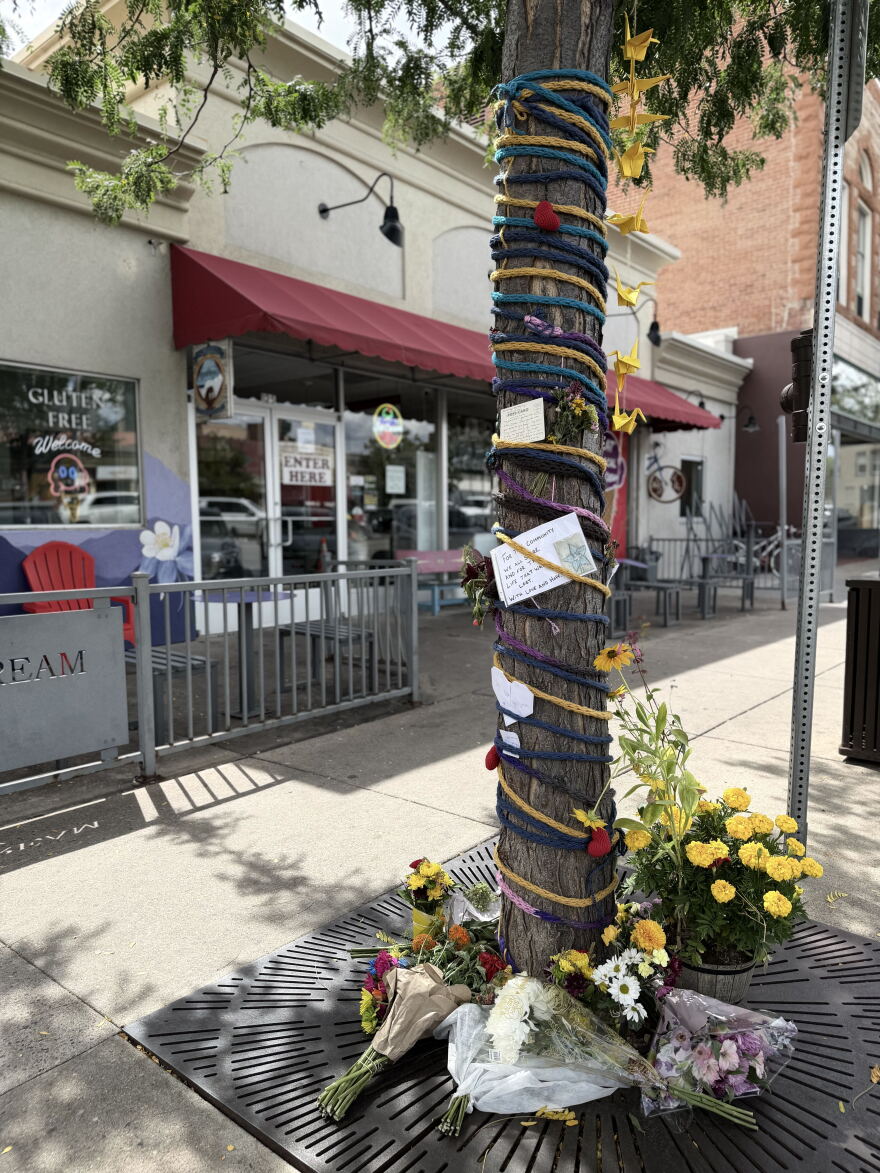 A tree covered in decorations on a sidewalk