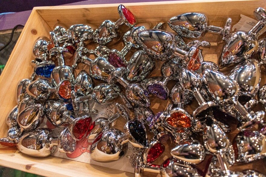 Metal butt plugs with heart-shaped jeweled ends in a box.