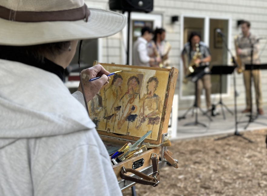 A painter paints PULSE Quartet at Glen Arbor Arts Center.