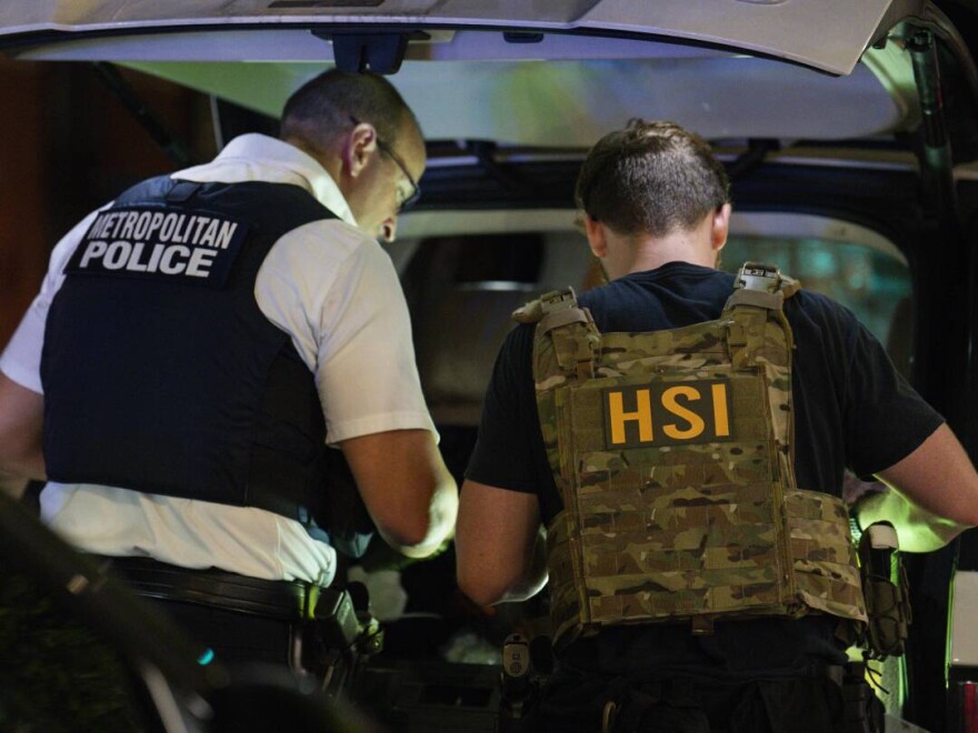 Metropolitan Police Department (MPD) and Homeland Security Investigations officers search inside a car during a traffic stop on Aug. 14, 2025, in Washington, D.C. While D.C. doesn't have a 287(g) agreement, MPD officers can cooperate with federal immigration enforcement agencies.