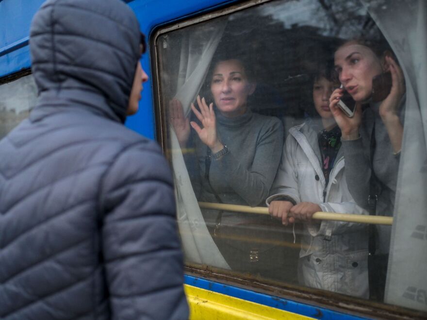 A family in an evacuation train says goodbye to a young man at the central train station in the southern city of Odessa. Russian forces have made progress in the south, overrunning the city of Kherson.
