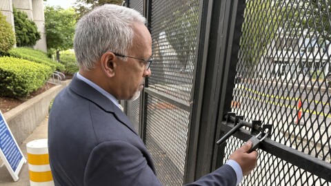 Federal judge Mustafa Kasubhai examines the fencing at the Eugene Federal Building, June 18, 2026.