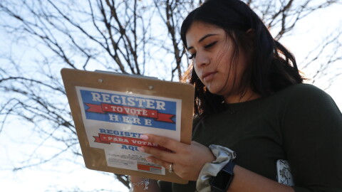 FILE - Karina Shumate, 21, a college student studying stenography, fills out a voter registration form in Richardson, Texas, on Jan. 18, 2020. Election vendors who print the ballots, registration forms and vote-by-mail cards used across the U.S. say their operations heading into the 2022 elections are running into the same delays and higher costs inflicting just about every industry since the pandemic began. (AP Photo/LM Otero, File)