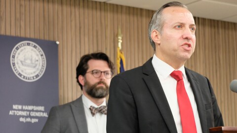 New Hampshire Attorney General John Formella announces the resolution of a case involving NSC-131, a hate group. Sean Locke, head of the state's Civil Rights Unit, is in the background.