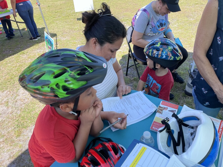 A mother takes 'well being survey' alongside her sons at Bernstein Park in Stock Island.