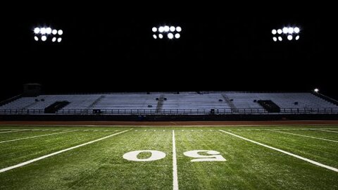 An image of a football stadium seating area from the point of view of someone standing in the center of the field on the 50 yard line.