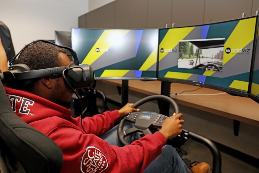A South Carolina State University junior industrial engineering major test drives the driver cockpit simulator in SC State's new SMART Virtual Reality Lab.