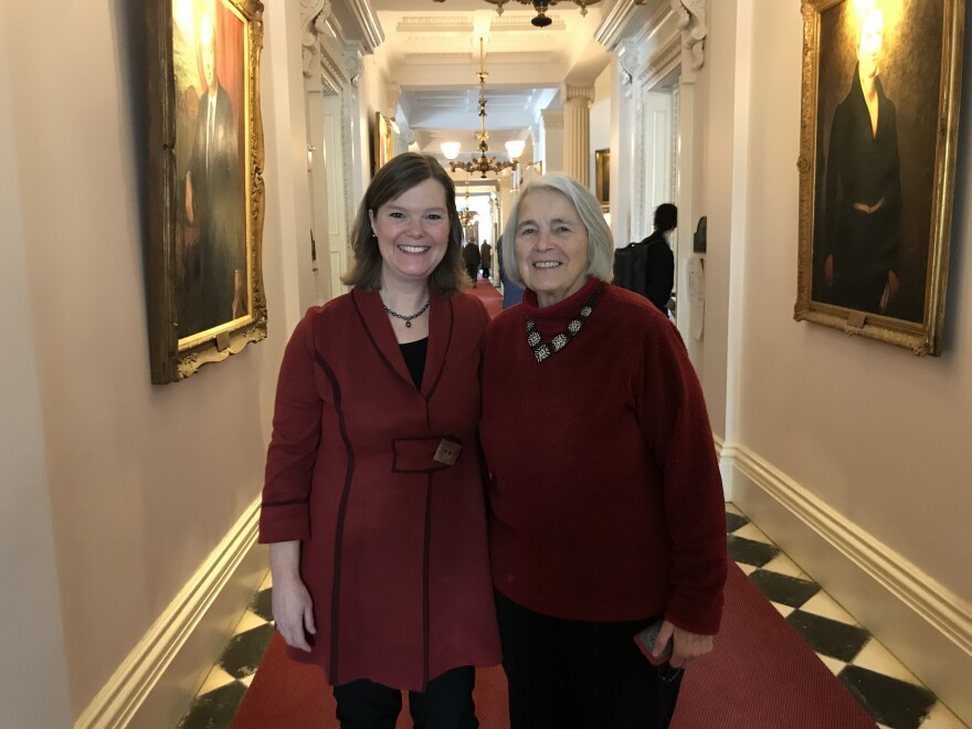 Two people standing in a hallway at the Statehouse with their arms around each other.